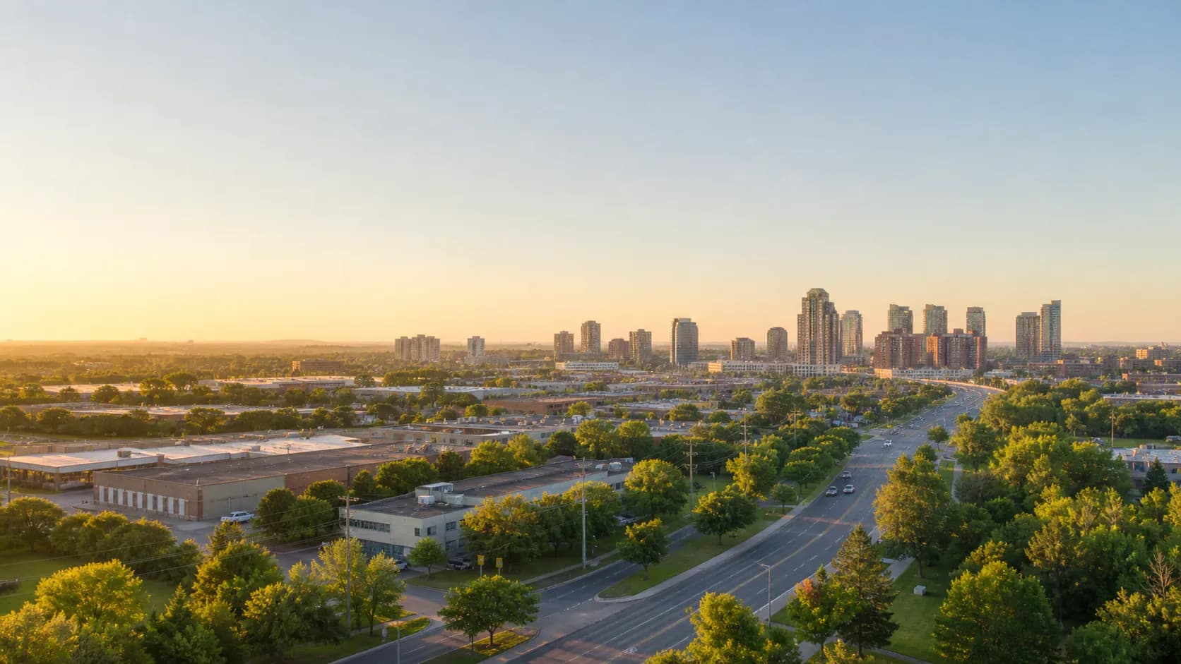 Editorial landscape representing Brampton, Ontario with mid-rise skyline, roads, trees, and nearby industrial buildings